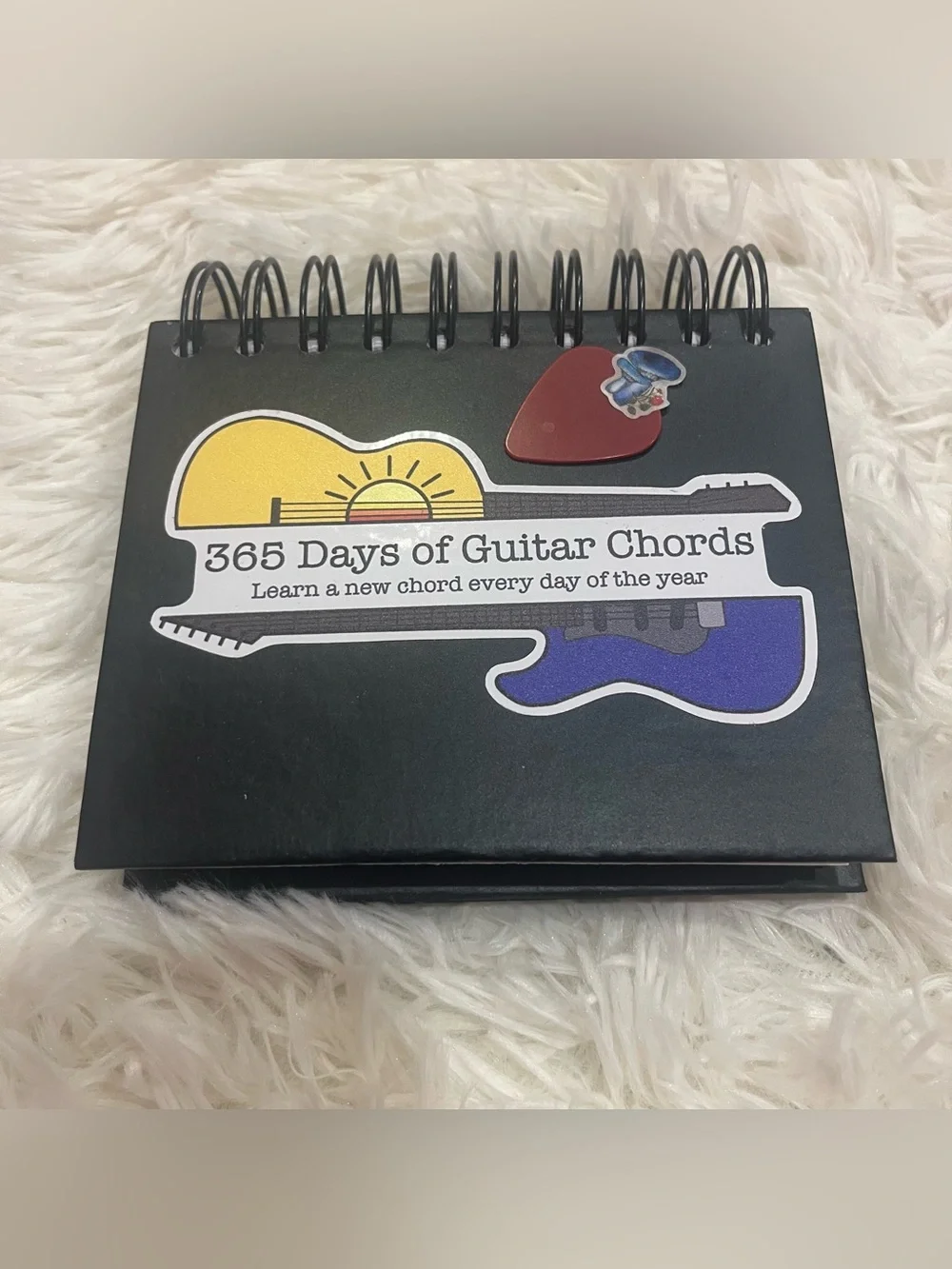365 Days of Guitar Chords Flipbook - Purple Guitar Graphic with a Pick